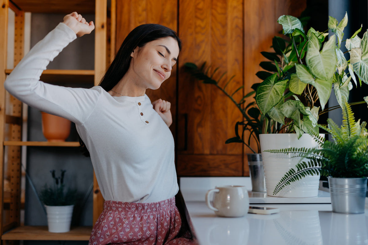 Woman stretches with protein coffee in front of her.