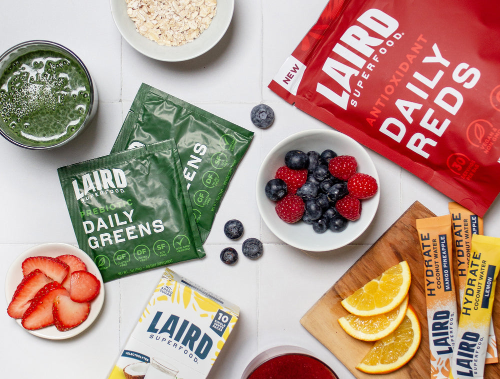 Laird Superfood daily reds bag with daily greens single packets, and hydrate box and packets with fruits and oats.