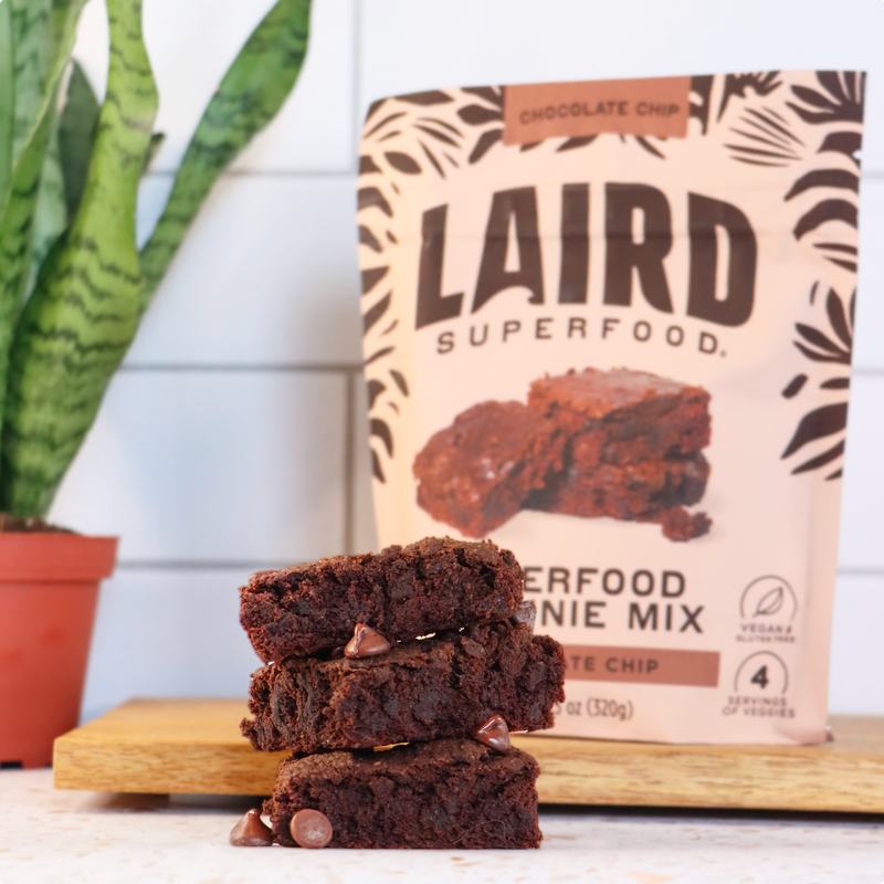 Laird Superfood brownies stacked in front of a bag of the mix