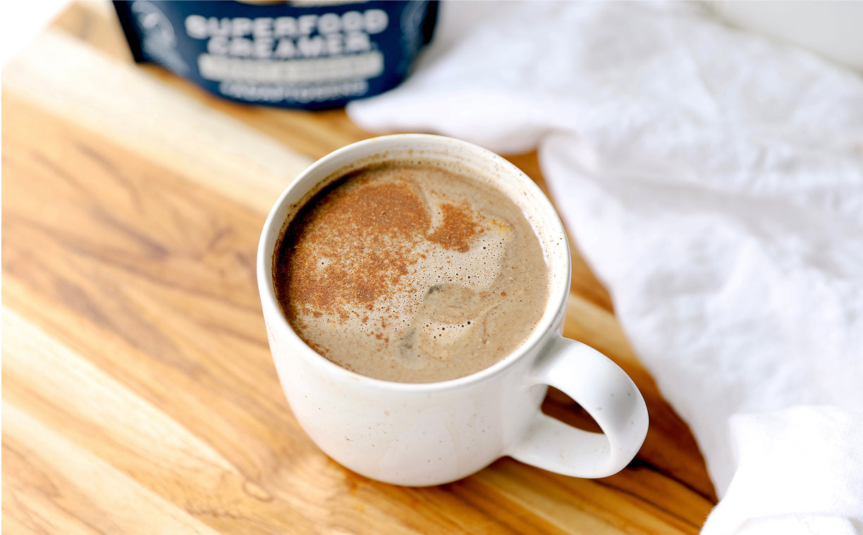 Laird Superfood Vanilla instant latte with a white glass mug filled with latte and vanilla bean next to it.