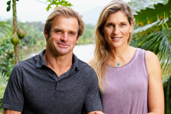 Laird Hamilton and Gabby Reece pose for portrait outside. 