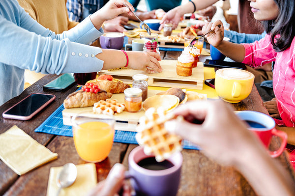 Friends gather at a table enjoying a home cafe set up. 
