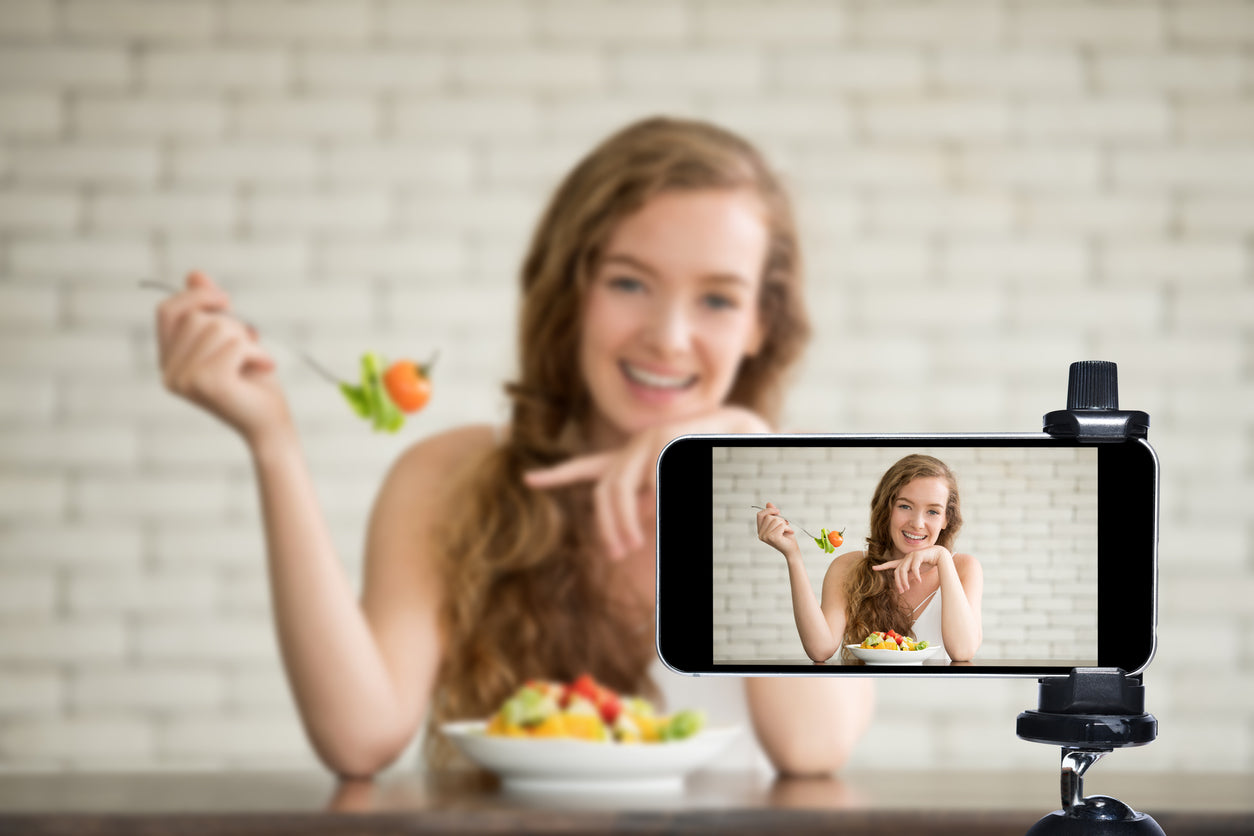 Female influencer eats while recording a tiktok video, hoping it will become a health trend. 
