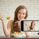 Female influencer eats while recording a tiktok video, hoping it will become a health trend. 