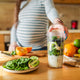 A pregnant mother makes a superfood shake, filled with leafy greens.