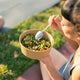 Woman eats a high-fiber salad with ingredients that can combat microplastics. 