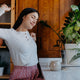 Woman stretches with protein coffee in front of her. 