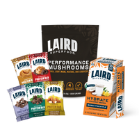 Laird Superfood's Performance Mushrooms with a variety pack of protein bars, and single serving Hydrate packets in mango pineapple flavor