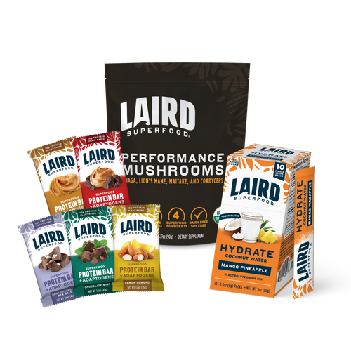 Laird Superfood's Performance Mushrooms with a variety pack of protein bars, and single serving Hydrate packets in mango pineapple flavor