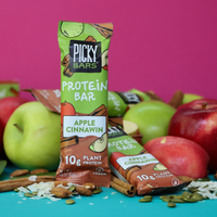 Apple Cinnawin Protein Bar next to flavorful ingredients