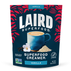 Laird Superfood Vanilla Creamer package with a blue mug and vanilla flower on a dark blue background.