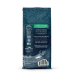 Back view of decaf coffee bag with blue leafy pattern, highlighting organic Arabica beans and mushroom blend benefits.