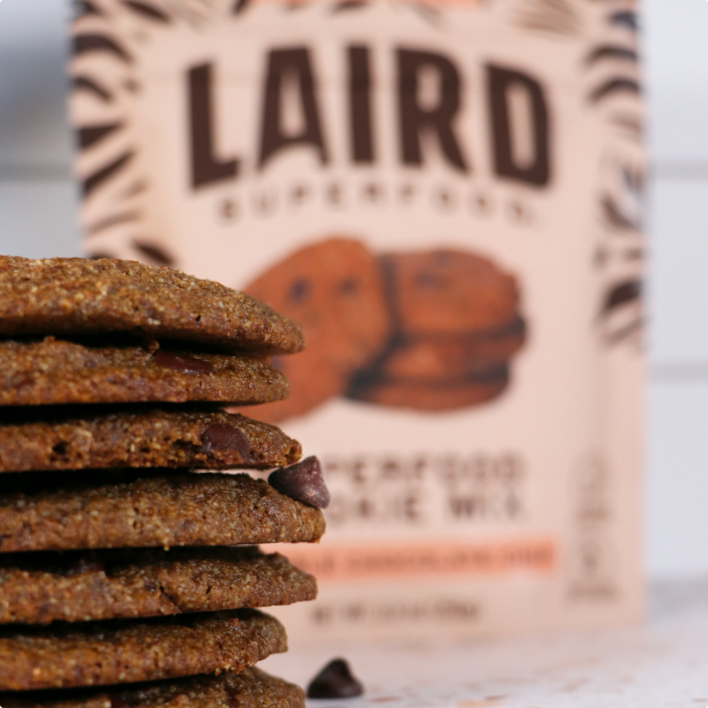 Laird Superfood cookies stacked in front of a bag of the mix