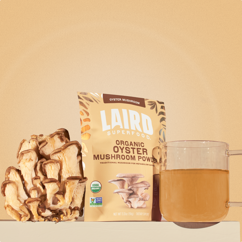 Laird Superfood oyster mushroom powder with the mushroom and a glass mug of the mushroom mix in water. 
