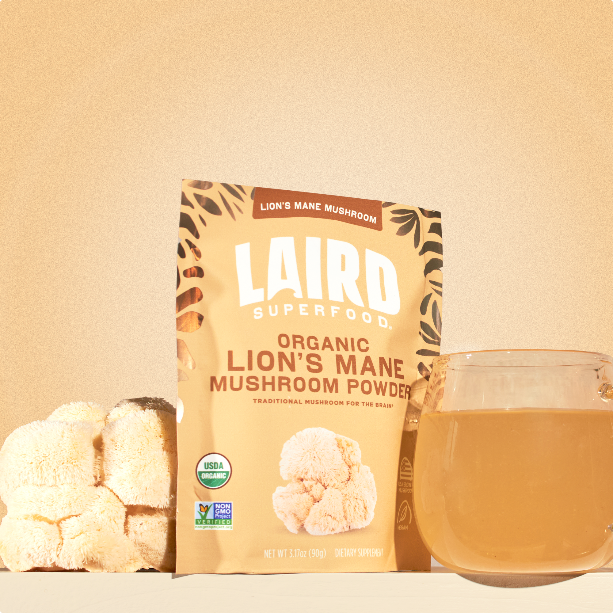 Laird Superfood lion's mane mushroom powder with the mushroom and a glass mug of the mushroom mix in water. 