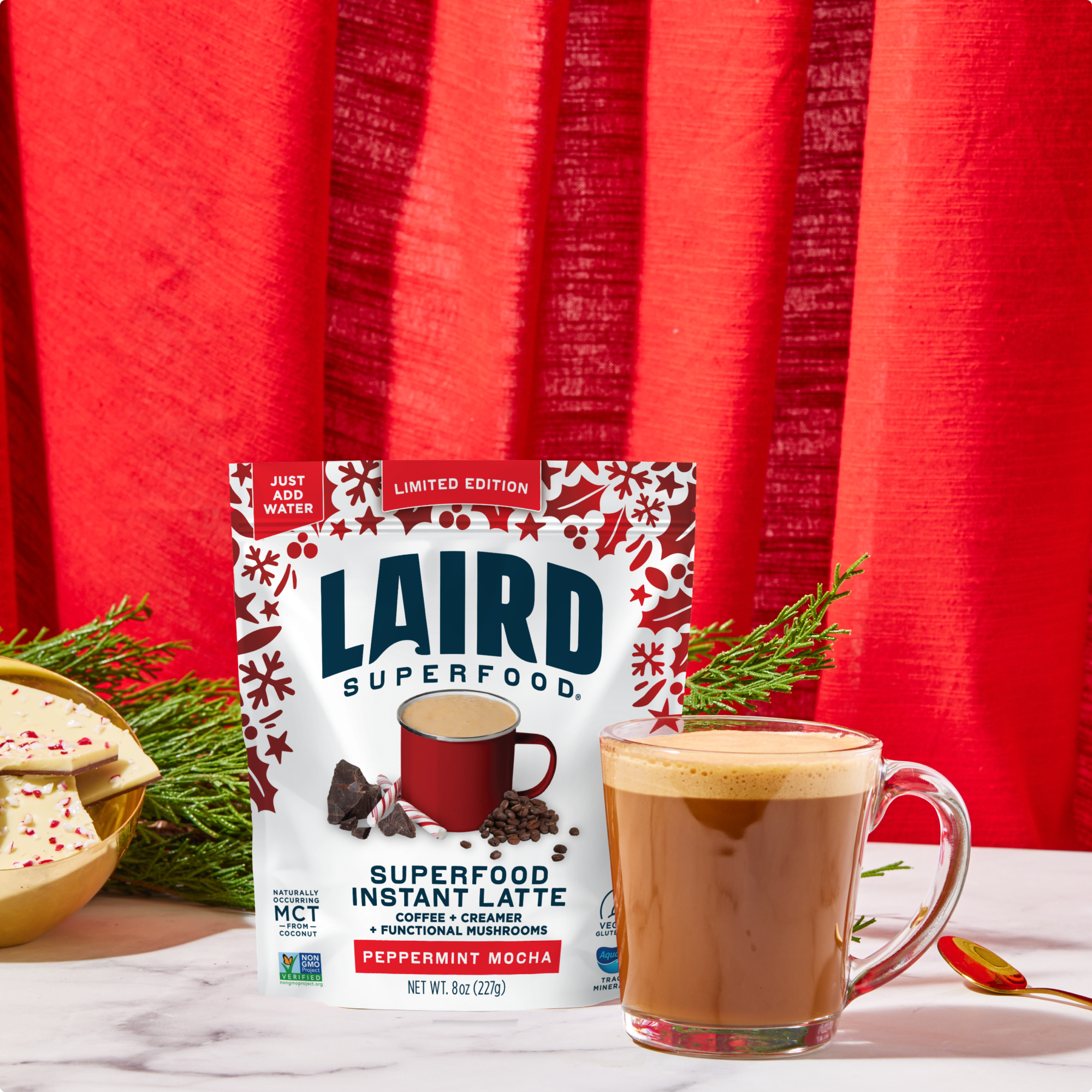Laird Superfood Instant Latte package with a cup of latte on a red curtain background