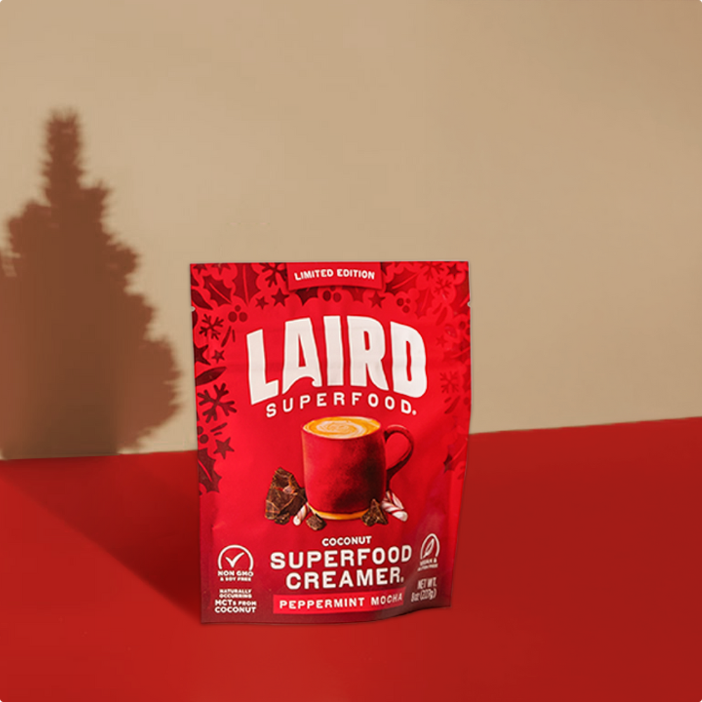 Red package of Laird Superfood Creamer on a red surface with a beige background