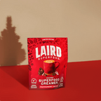 Red package of Laird Superfood Creamer on a red surface with a beige background