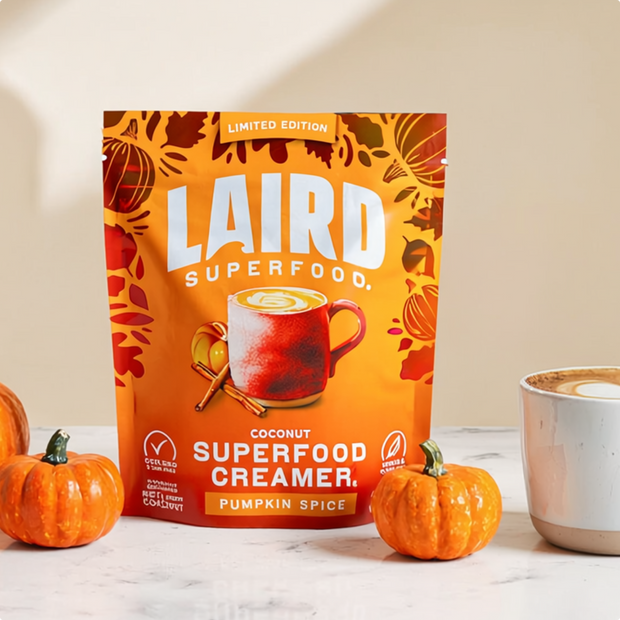 Laird Superfood Coconut Superfood Creamer Pumpkin Spice packaging with pumpkins and a coffee cup on a light background
