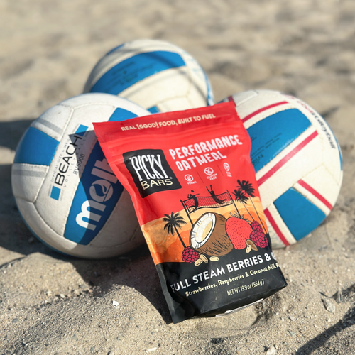 Picky Bar's Oatmeal with Berries and Cream in the sand on the beach on top of beach volleyballs